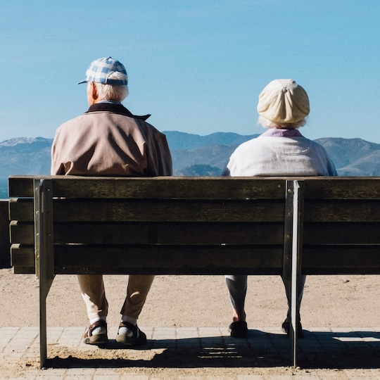 Fit elder surfing a wave at sunset